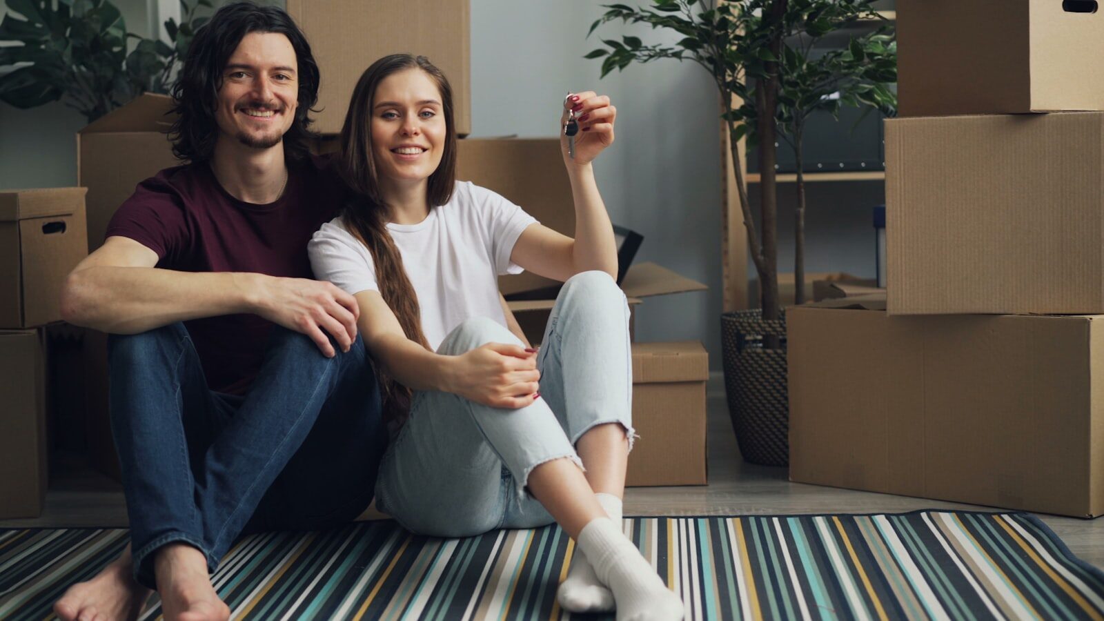 A happy couple holding the keys to their new Florida home among moving boxes