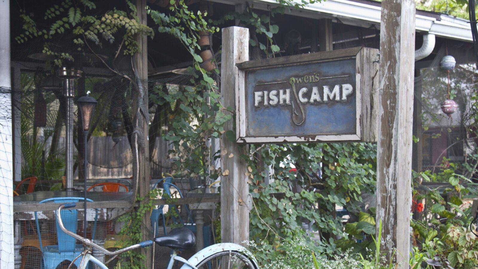 The rustic hand-painted sign and garden at Owen's Fish Camp in Sarasota